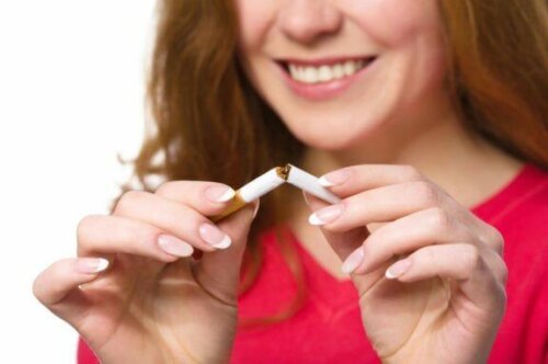 En kvinne som brekker en sigarett i to.