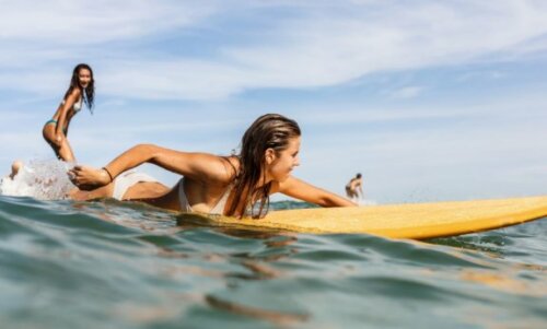 Jenter surfer i havet
