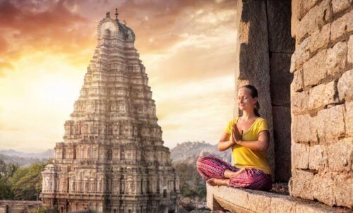 Kvinne som mediterer foran et tempel
