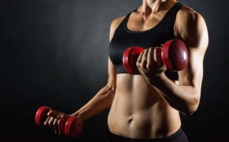En kvinnelig idrettsutøver som løfter vekter for å forbedre kroppssammensetningen