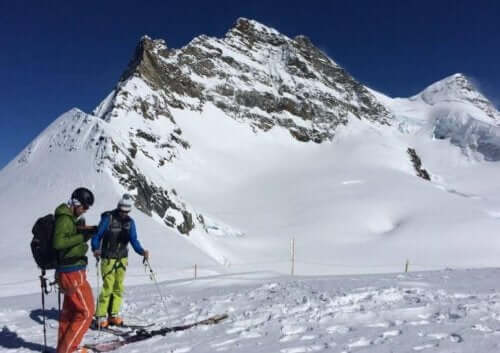 menn som står på ski på fjellet