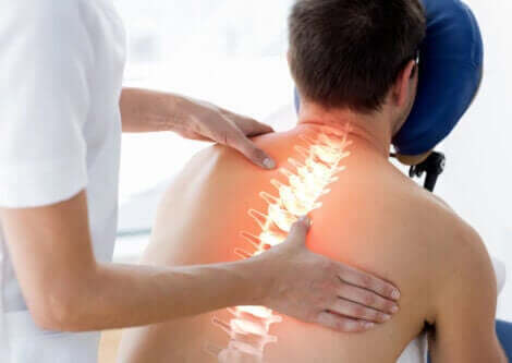En fysioterapeut som arbeider på pasientens rygg.