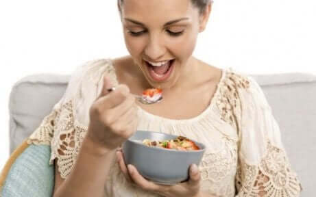 Kvinne som spiser en bolle med fiberrik mat for å gjenopprette tarmfloraen
