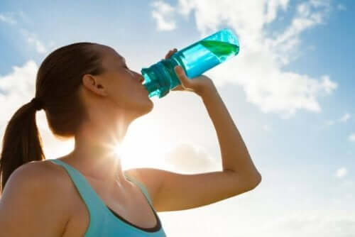Kvinne som drikker fra en vannflaske.
