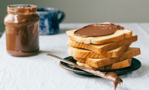 Nutella op geroosterd brood met een open pot chocoladespread