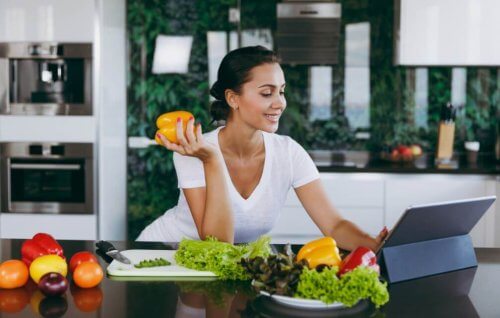 vrouw eet groente achter laptop