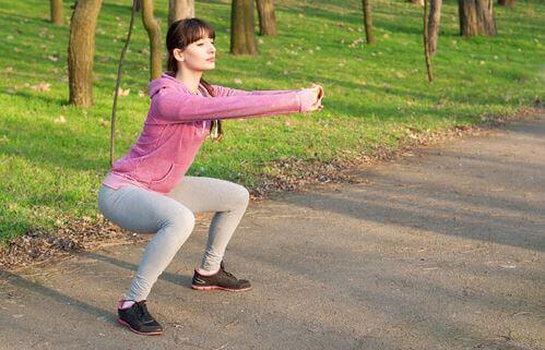 Vrouw doet squats in het park