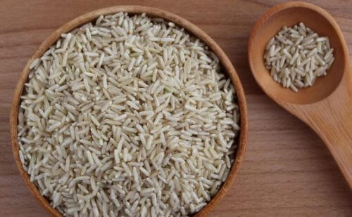 rijstkorrels in een houten schaal en lepel