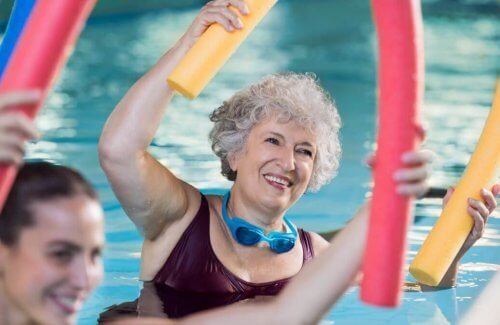oudere vrouw doet mee aan groepsles in zwembad