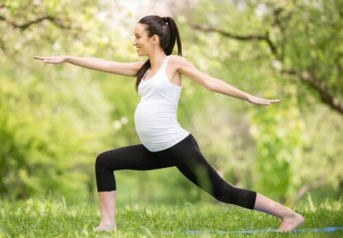 Zwangere vrouw doet yoga in park
