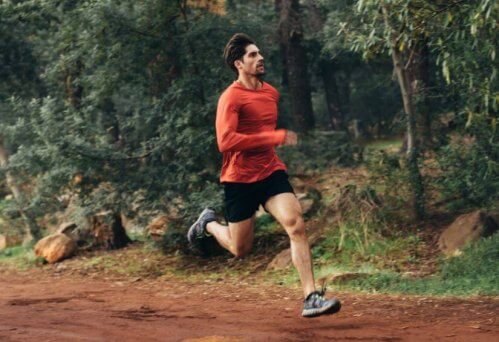 Man in rood shirt trailrunning