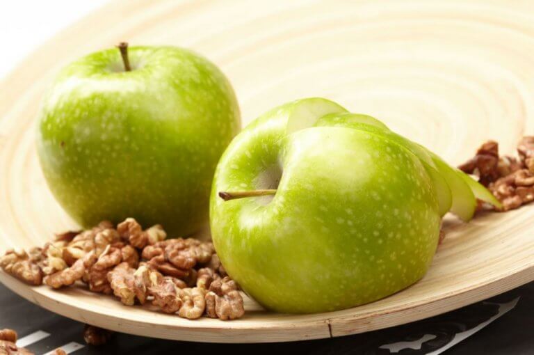 Jabłka i orzechy na drewnianej misce - zdrowe przekąski