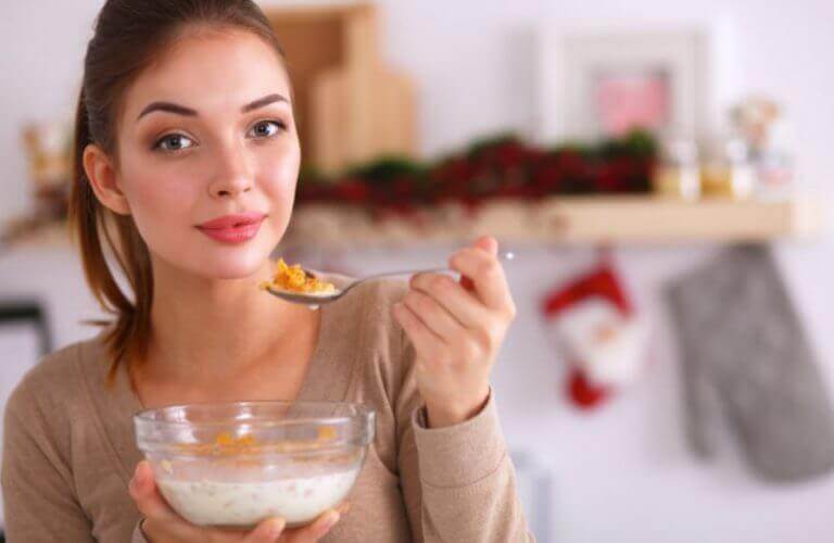 Kobieta jedząca z miski płatki śniadaniowe z mlekiem