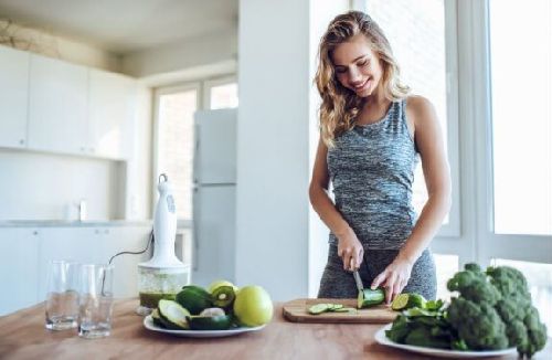 Kobieta przygotowująca zdrowe jedzenie - jak kontrolować głód