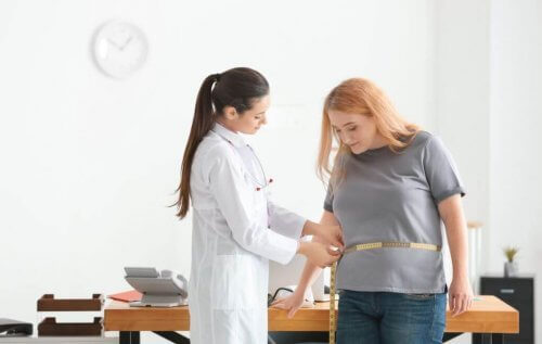 Lekarka mierząca obwód w talii otyłej kobiecie