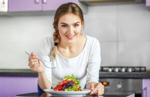 Kobieta jedząca kolorowe sałatki