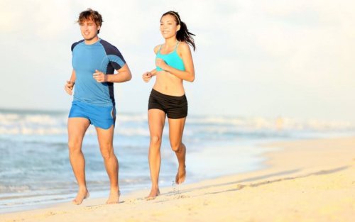 cotygodniowe zawody - Kobieta i mężczyzna biegnący po plaży