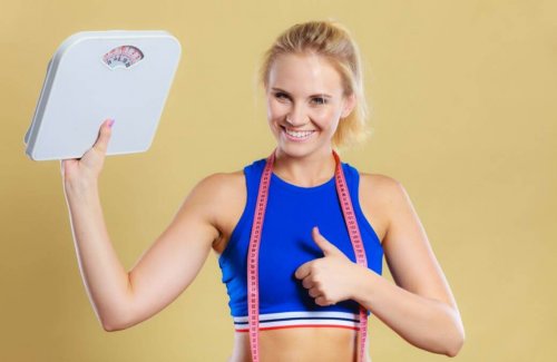 Kobieta trzymająca wagę, pokazująca kciuk do góry - dieta ketogeniczna pozwoli schudnąć