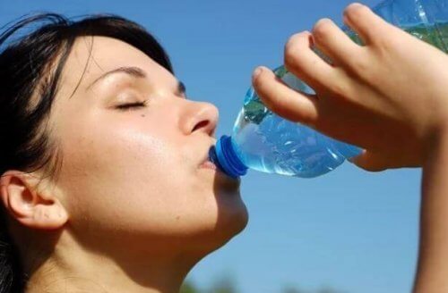 Kobieta pijąca wodę z butelki