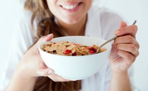 Uśmiechnięta kobieta jedząca płatki śniadaniowe