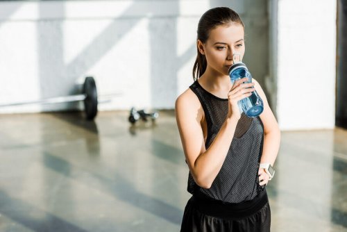 Kobieta pije wodę na siłowni