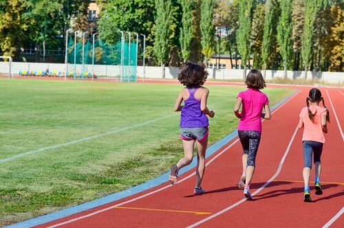 Dzieci biegnące po torze treningowym - szkolne rozgrywki i programy sportowe