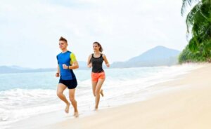 Kobieta z partnerem biegną po plaży i utrata mięśni 
