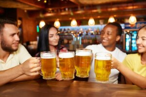 Picie alkoholu w pubie, kufle z piwem
