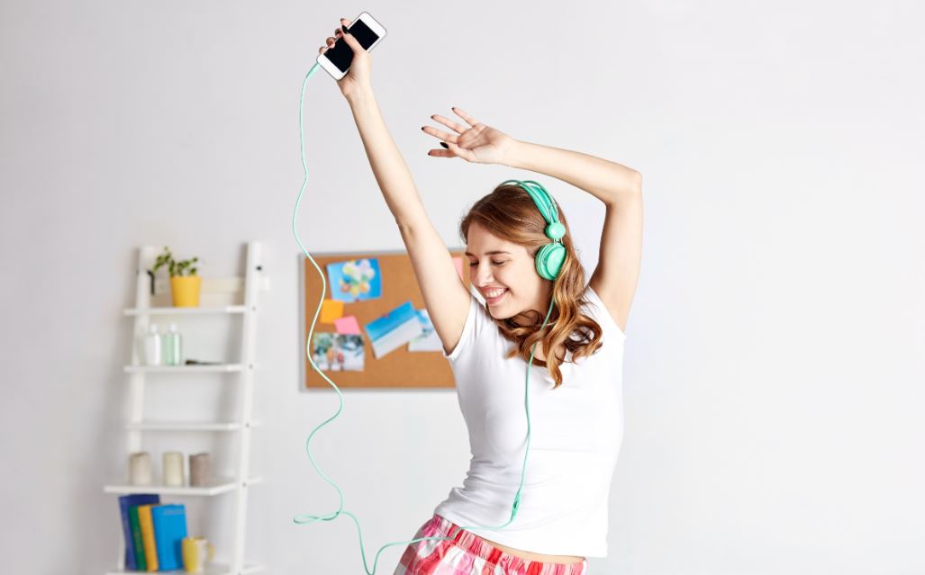 Menina dançando com ipod em casa