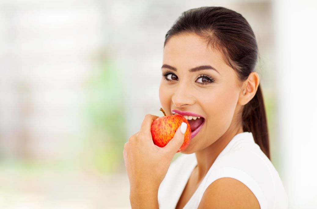 Dieta macrobiótica: mulher comendo uma maçã