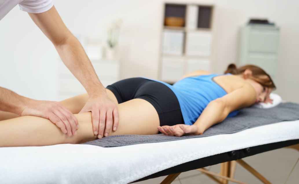 Mulher recebendo massagem nas pernas depois de treinar