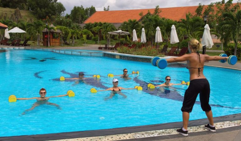 Pessoas fazendo hidroginástica na piscina de um hotel