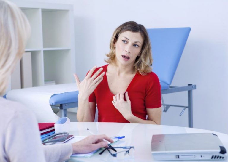 Paciente explicando sintomas da menopausa para uma médica