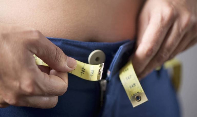 pessoa medindo gordura abdominal