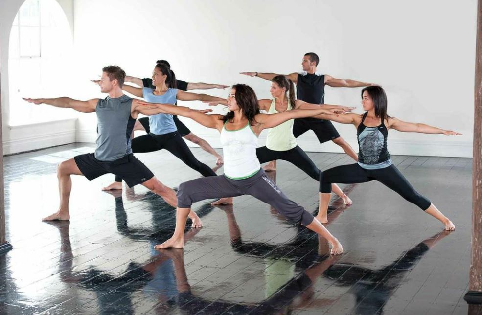 Alunos fazendo yoga em uma aula na academia
