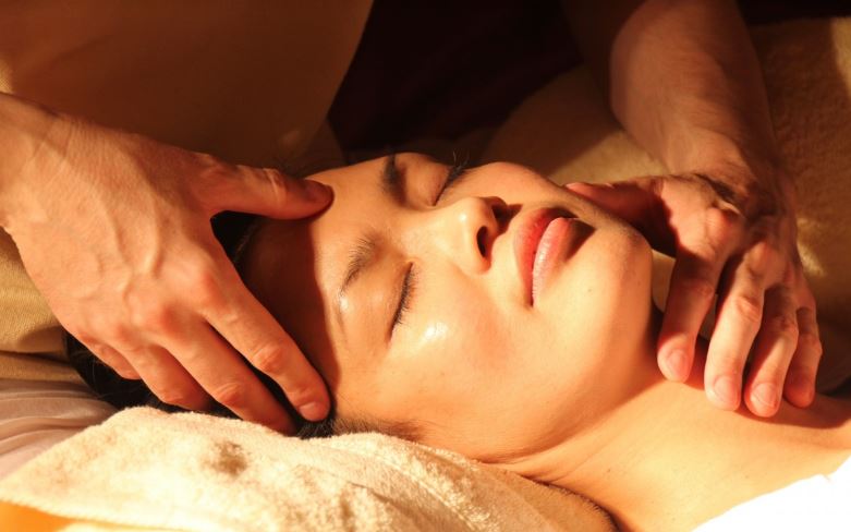 Mulher recebendo massagem para dor de cabeça