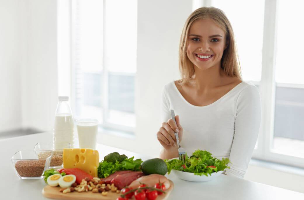 Mulher com ´vários alimentos saudável como legumes e frutas