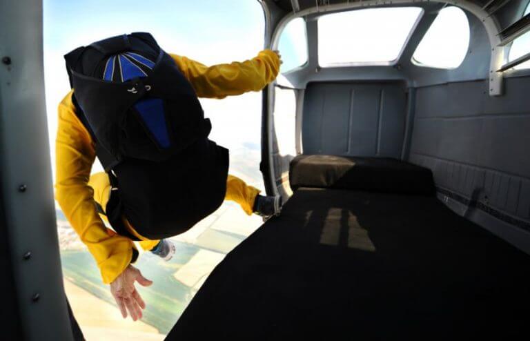 Homem saltando do avião fazendo paraquedismo