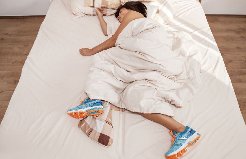 Mulher dormindo com tênis de corrida