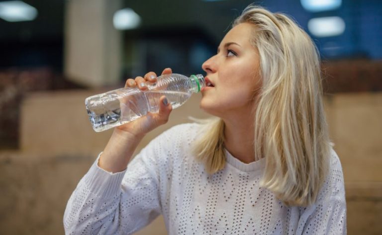 Menina bebendo uma garrafa de água