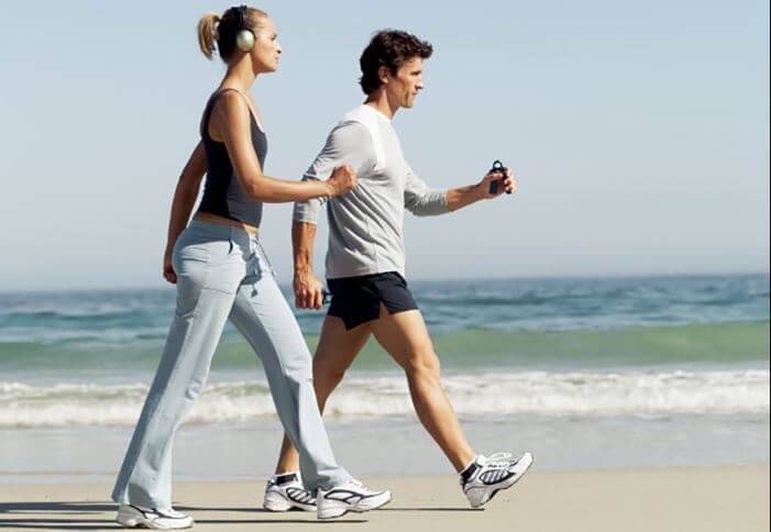 Homem e mulher caminhando na praia