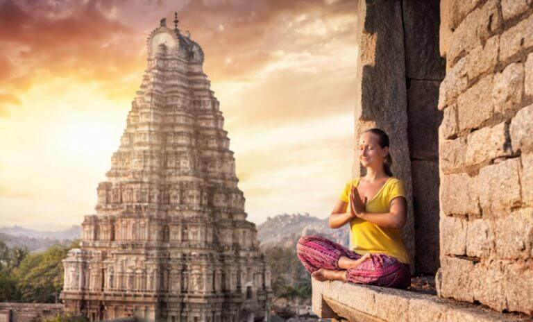Mulher meditando na diante de templo