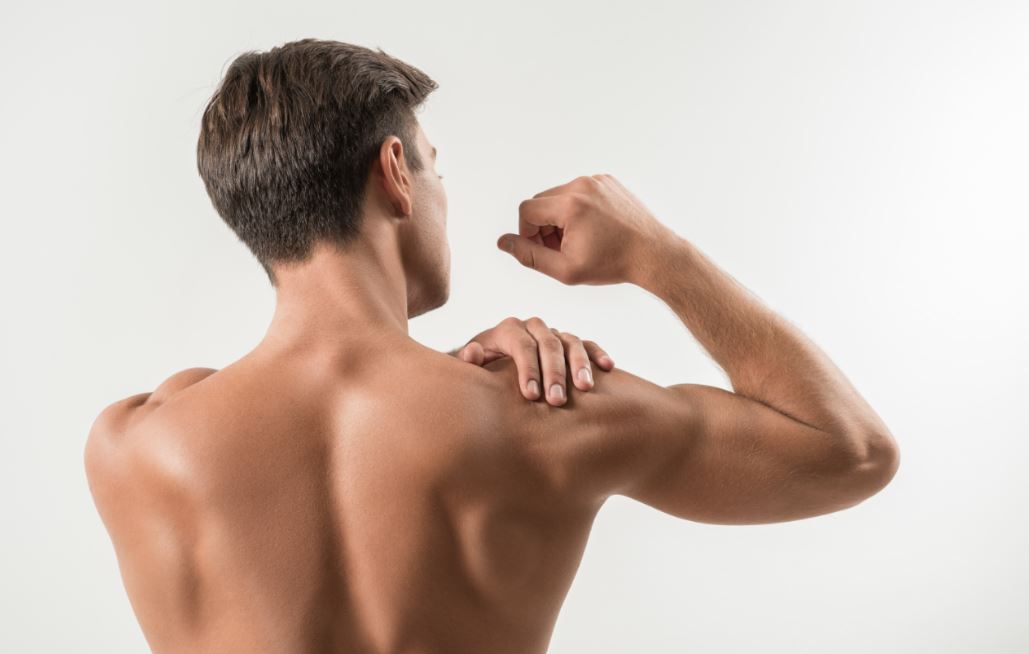 Homem sem camisa vendo os músculos do braço