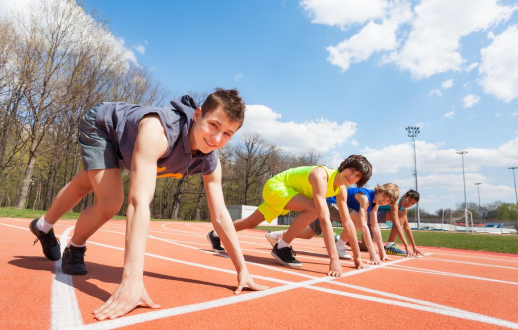 Crianças prontas para correr em uma pista de atletismo
