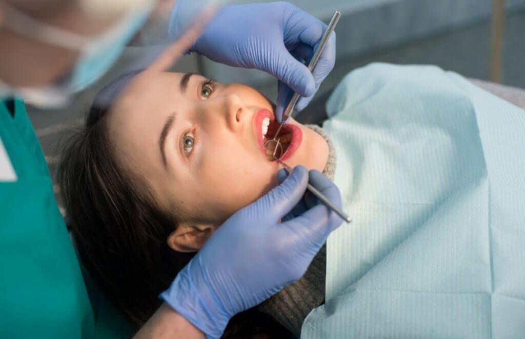 Uma mulher fazendo um check-up de cárie no dentista.
