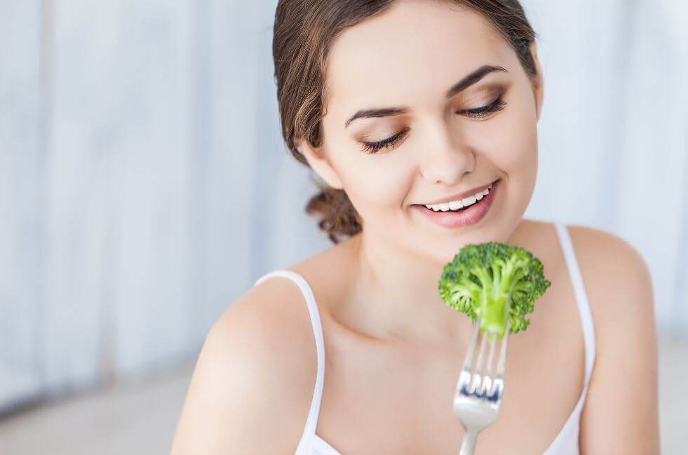 Garota comendo brócolis