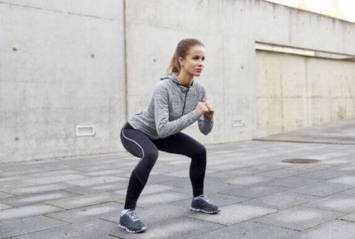 kalori yakmak için squat hareketi yapan kadın