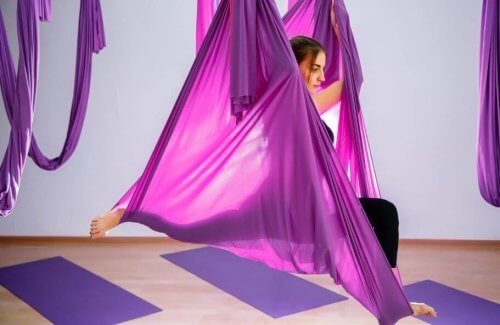 mor kumaşlarla hava yogası yapan kadın