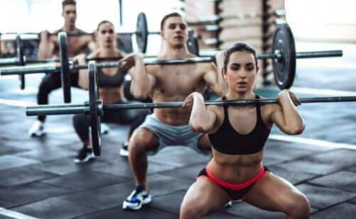 Spor salonunda ağırlık kaldıran bir grup insan