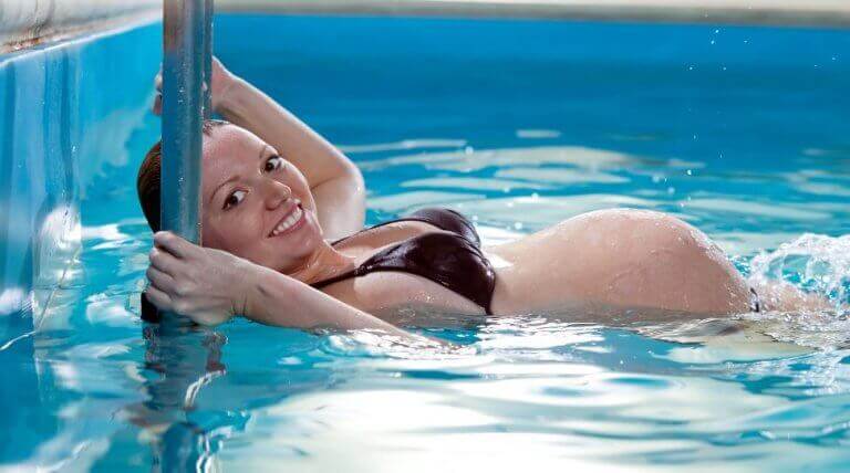 Havuzda yüzen hamile kadın